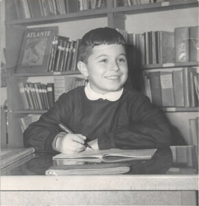 A black and white photograph of Giorgio Parisi as a child writing