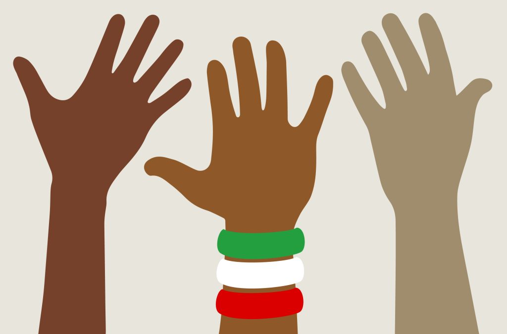 Three demonstrating hands. The hand in the middle wears a set of bracelets representing the colours of Iran.